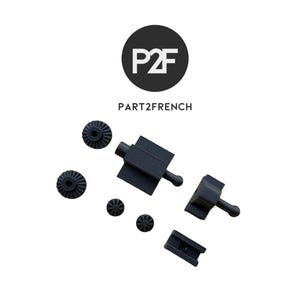 Könnte beinhalten: Verschiedene schwarze Kunststoff-Mechanikteile, darunter Zahnräder und Verbinder, sind vor weißem Hintergrund angeordnet. Das Logo "P2F" in einem schwarzen Kreis und der Text "PART2FRENCH" befinden sich oben.