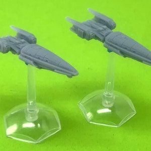 May include: Two gray miniature spaceships on clear plastic stands. The spaceships have a sleek, futuristic design with pointed noses and wings.