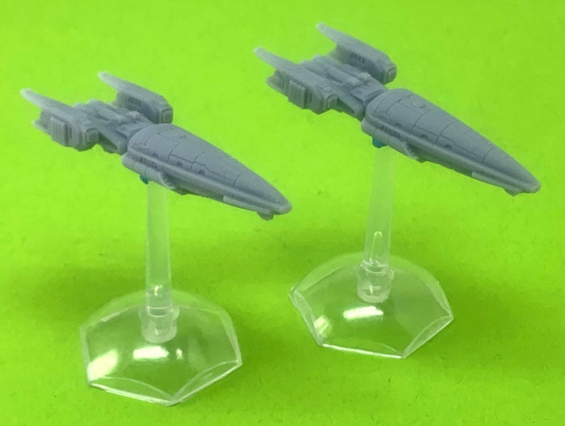 May include: Two gray miniature spaceships on clear plastic stands. The spaceships have a sleek, futuristic design with pointed noses and wings.