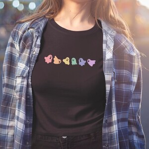 May include: A black t-shirt with a row of rainbow-colored ghost illustrations.