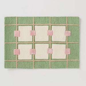 Puede incluir: Alfombra rectangular con fondo verde y dise&ntilde;o de cuadr&iacute;cula. Las l&iacute;neas de la cuadr&iacute;cula son de color beige y los cuadrados est&aacute;n rellenos de blanco roto. Cuadrados rosas acent&uacute;an las intersecciones de la cuadr&iacute;cula. La alfombra tiene un aspecto texturizado y tejido.