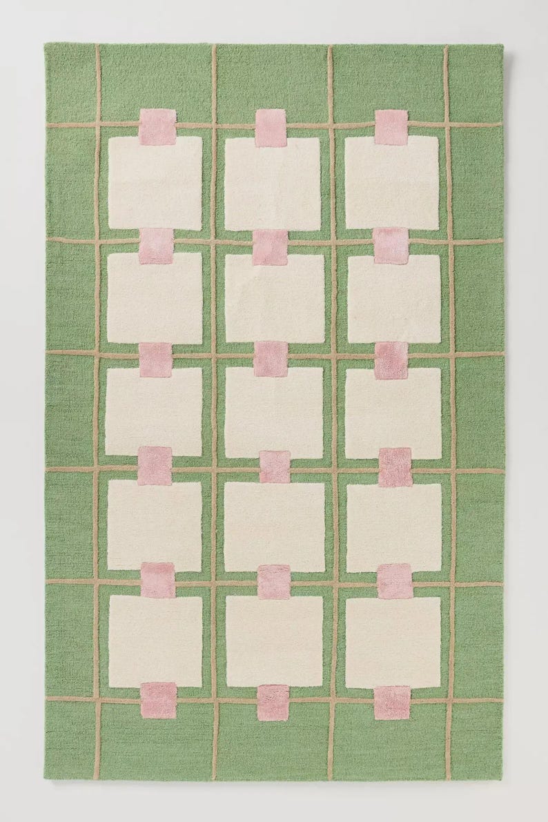 Puede incluir: Una alfombra rectangular con fondo verde y un patr&oacute;n de cuadr&iacute;cula. La cuadr&iacute;cula est&aacute; hecha de l&iacute;neas beige, rect&aacute;ngulos blanquecinos y cuadrados rosas. La alfombra es un revestimiento decorativo para el suelo.