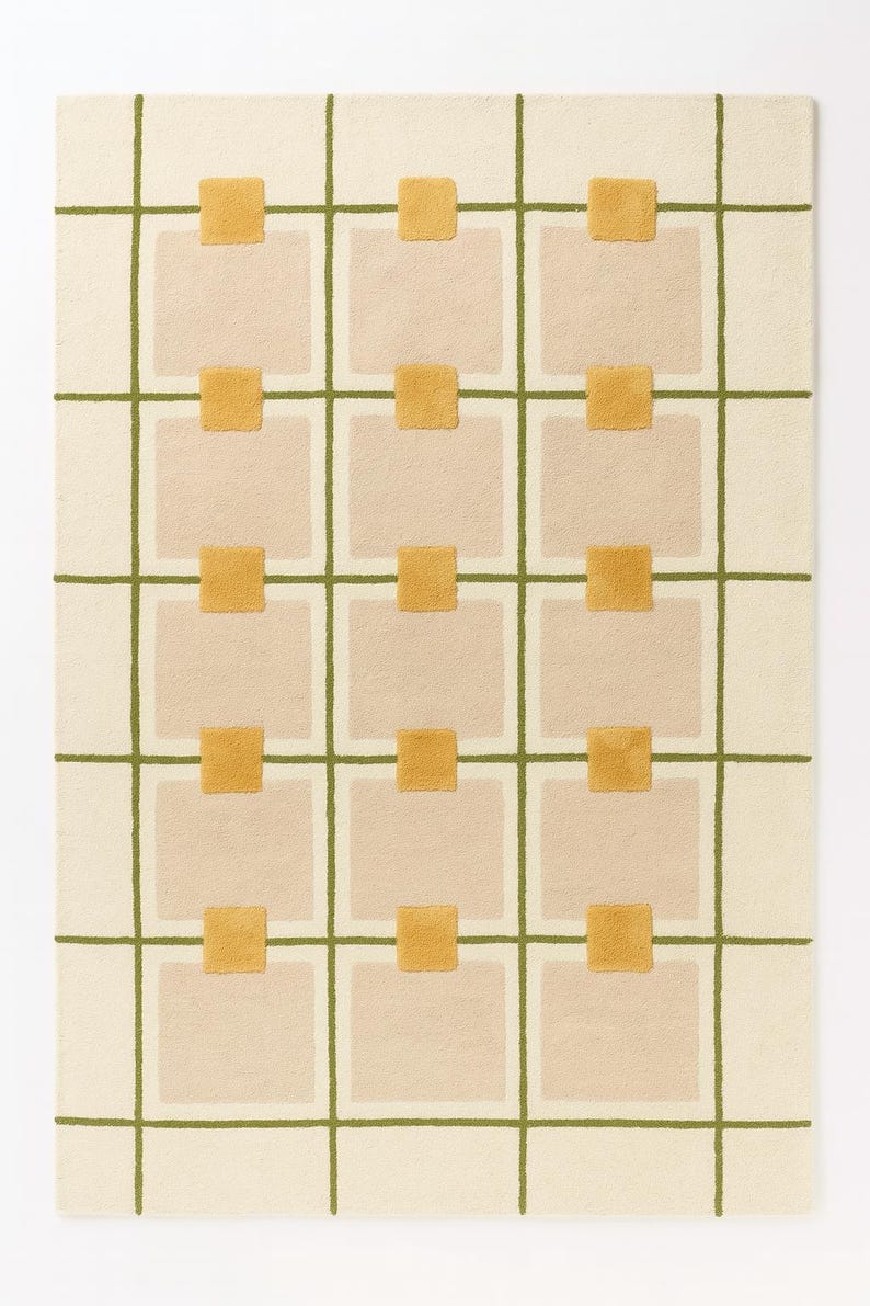 May include: A rectangular rug with a grid pattern. The rug features a cream-colored background with a grid of olive green lines. Beige squares are interspersed within the grid, with small, mustard-yellow squares at the intersections.