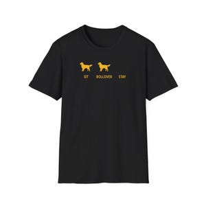 May include: A black short-sleeved t-shirt featuring a yellow graphic of two dogs and the text SIT, ROLLOVER, and STAY. The design shows a dog silhouette above the word SIT, a dog silhouette above the word ROLLOVER, and an empty space above STAY.