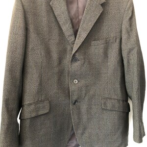 May include: A grey tweed blazer with a three-button fastening.