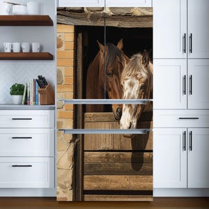 Può includere: Un rivestimento per frigorifero con due cavalli in una stalla di legno. Un cavallo è marrone, l'altro è di colore beige chiaro. I cavalli guardano fuori dalla stalla. Lo sfondo è un muro di mattoni.
