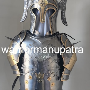 May include: A polished steel suit of armor featuring a helmet with tall, curved side crests and a breastplate embossed with a tree design and gold-toned star accents. The armor includes shoulder pauldrons with gold-toned trim and metal rivets.