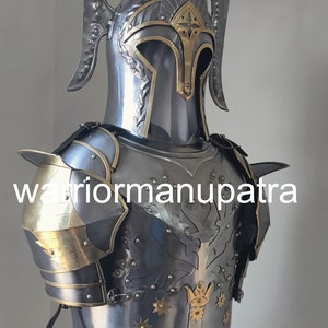 May include: A polished steel suit of armor featuring a helmet with tall curved side crests and a brass-accented visor. The breastplate displays an embossed tree design with brass star-shaped rivets and a central crown motif, labeled warriormanupatra.