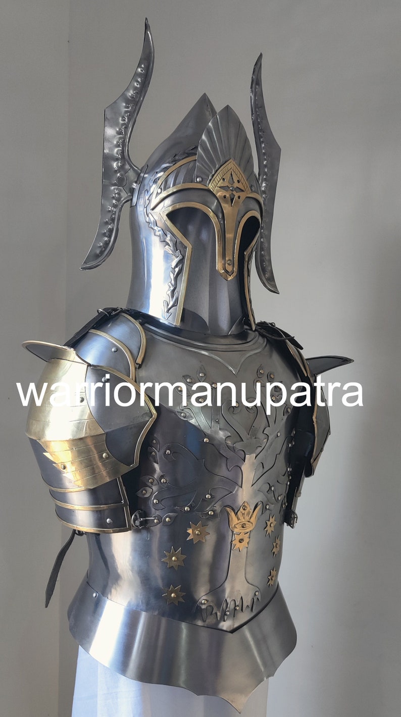 May include: A polished steel suit of armor featuring a helmet with tall curved side crests and a brass-accented visor. The breastplate displays an embossed tree design with brass star-shaped rivets and a central crown motif, labeled warriormanupatra.