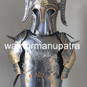 May include: A polished steel suit of armor featuring a helmet with tall, curved side crests and a breastplate engraved with a tree motif and gold-toned star accents. The armor includes shoulder pauldrons with gold-toned trim and the text warriormanupatra.
