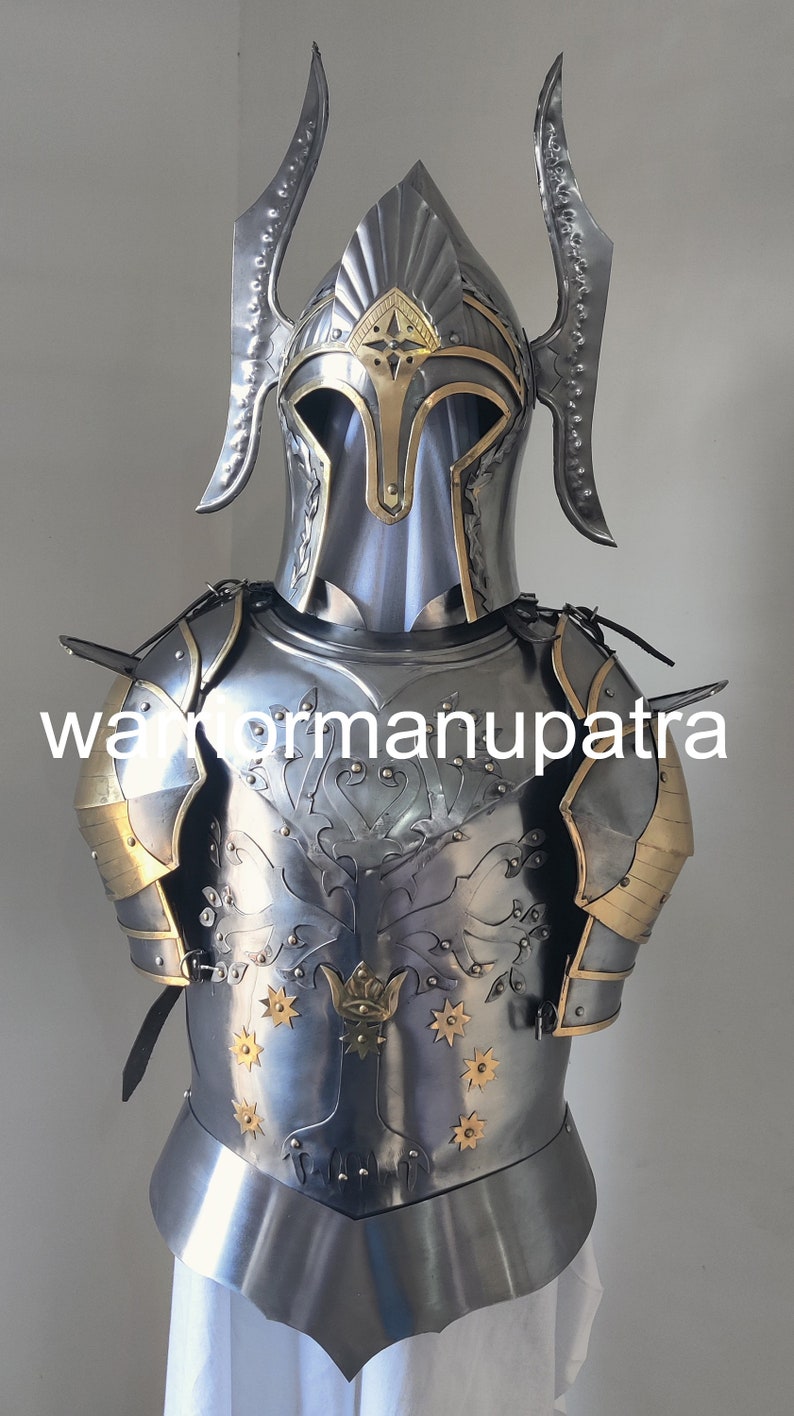 May include: A polished steel suit of armor featuring a helmet with tall, curved side crests and a breastplate engraved with a tree motif and gold-toned star accents. The armor includes shoulder pauldrons with gold-toned trim and the text warriormanupatra.