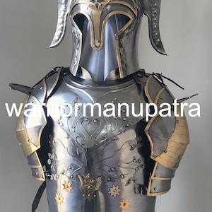 May include: A polished steel suit of armor featuring a helmet with two tall, curved side fins and a gold-trimmed visor. The chest plate displays an engraved tree motif accented with gold-toned star inlays and the text warformanupatra.