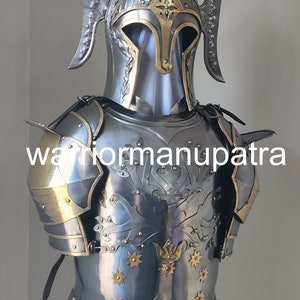 May include: A polished steel suit of armor featuring a helmet with tall side crests and a breastplate decorated with an embossed tree motif and brass star accents. The chest piece displays the text warriormanupatra across the center.