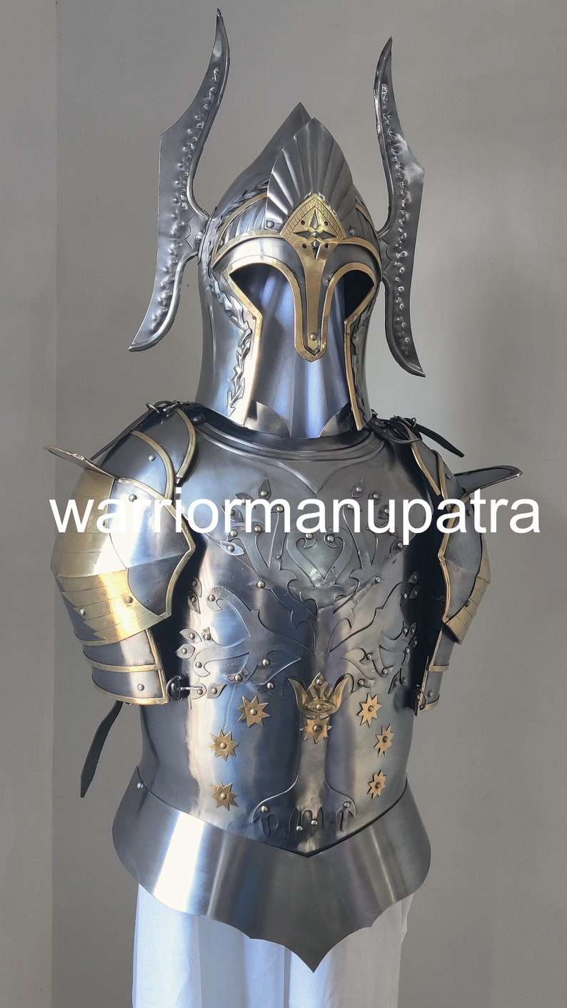 May include: A polished steel suit of armor featuring a helmet with tall side crests and a breastplate decorated with an embossed tree motif and brass star accents. The chest piece displays the text warriormanupatra across the center.
