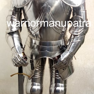 May include: Full body suit of silver plated armor with a red plume on the helmet. The armor is standing on a wooden base and holding a sword.