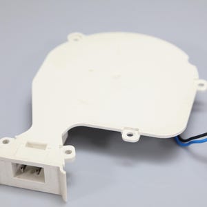 May include: A white plastic blower fan housing with a rounded main body and a rectangular outlet port. The component features four mounting tabs and includes a short wire harness with one black wire, one blue wire, and a white two-pin connector.