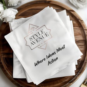 May include: A stack of white napkins with a rose gold logo that reads "STYLE AVENUE" and the tagline "Where Ideas Meet Action". The napkins are stacked on a wooden tray.