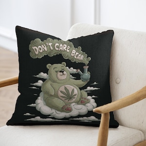 May include: A black and green throw pillow with a cartoon illustration of a green bear smoking a bong. The text "Don't Care Bear" is written in white above the bear.