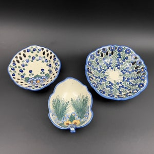 May include: Three ceramic bowls with blue and white floral patterns. The bowls are all different shapes and sizes. The largest bowl has a scalloped edge and a floral pattern that is more intricate than the other two bowls. The smallest bowl is a leaf shape with a simple floral pattern.