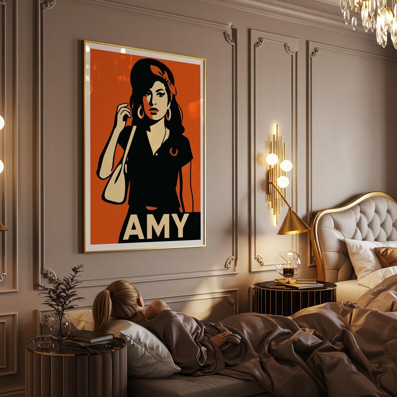 Pu&ograve; includere: Una stampa incorniciata in stile pop art con una donna con un top nero e una fascia rossa su sfondo arancione. La stampa ha il nome "AMY" in bianco in basso. L'opera d'arte &egrave; esposta in una camera da letto.