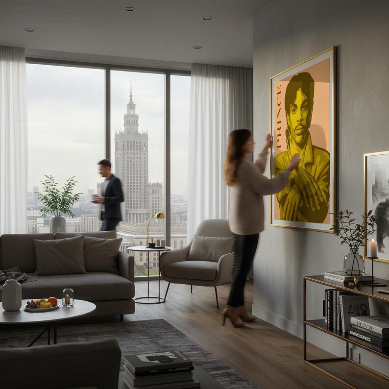 Op de afbeelding: Een ingelijste poster met een portret van Prince in tinten geel en olijfgroen. Het kunstwerk wordt tentoongesteld in een moderne woonkamer met een groot raam met uitzicht op een stadsgezicht. Het woord "PRINCE" staat verticaal aan de linkerkant van de poster.