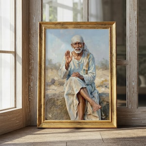 May include: A framed painting depicts a seated figure with a white beard and head covering, raising a hand in a gesture of blessing. The artwork is set in a gold-colored frame, with a light blue and tan background. The painting is displayed on a wooden surface.
