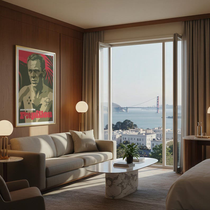 May include: A contemporary living room featuring a beige sofa, a marble coffee table, and a framed movie poster. The room has large windows offering a view of the Golden Gate Bridge. Decorative lamps and a small plant enhance the decor.