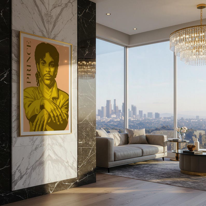 Op de afbeelding: Een ingelijste kunstdruk met een geel- en perzikkleurig portret van Prince, met de naam "PRINCE" verticaal afgedrukt aan de linkerkant. Het kunstwerk hangt aan een marmeren muur in een moderne woonkamer met uitzicht op de stad.