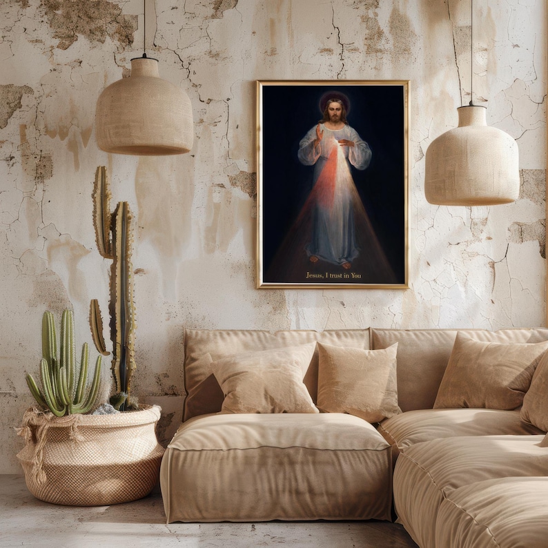 May include: A framed religious artwork depicts a figure with a halo, radiating light. The figure is wearing a white robe with blue accents. The text "Jesus, I trust in You" is at the bottom. The artwork is displayed above a beige sofa.