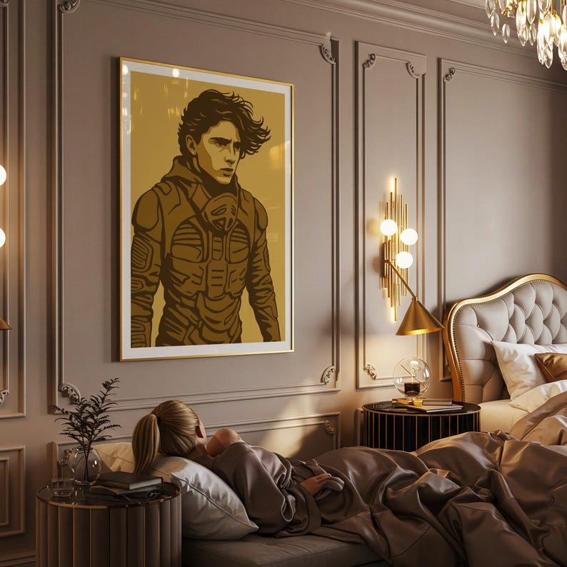 May include: A framed art print featuring a stylized illustration of a person in a futuristic outfit. The artwork is in shades of brown and gold, with a gold frame. The print is hanging on a gray wall in a bedroom setting.
