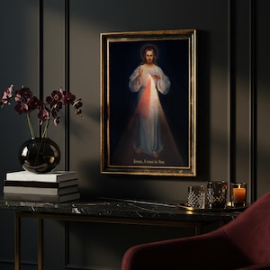 May include: Framed religious artwork depicting Jesus with a halo, radiating light. The painting features a dark background with the text "Jesus, I trust in You" at the bottom. The frame is gold-colored.
