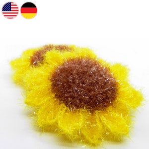 Puede incluir: Dos paños de cocina de ganchillo amarillos en forma de girasol con centros marrones. Los paños de cocina están hechos con un hilo esponjoso y tienen un acabado brillante.