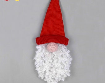 May include: A red crocheted gnome hat with a white crocheted beard and a pink nose. The gnome is hanging from a string.