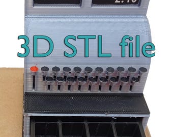May include: A 3D-printed cash register model in gray and black, with the text "3D STL file" in teal. The display shows "2.46". The cash drawer is open, revealing four compartments. The model has a series of black buttons.