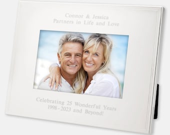 May include: Silver picture frame with a photo of a couple and an engraved message that reads "Connor & Jessica Partners in Life and Love Celebrating 25 Wonderful Years 1998-2023 and Beyond!"