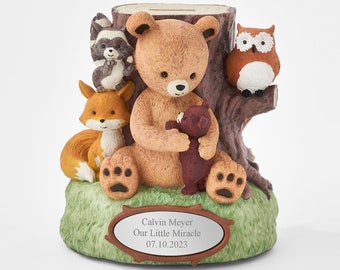 May include: A brown teddy bear piggy bank sitting on a tree stump with a raccoon, fox, owl, and a smaller teddy bear. The piggy bank has a personalized plaque that reads "Calvin Meyer Our Little Miracle 07.10.2023".