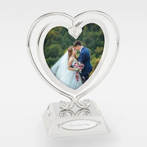May include: Silver heart-shaped picture frame with a double frame design. The frame has a small heart detail at the top and a base with the inscription "Forever Starts Today".