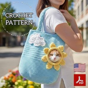 May include: Light blue crochet tote bag with a white cloud and yellow sun design. The bag features a cat wearing a yellow sun hat. The text "CROCHET PATTERN" is displayed on the bag.