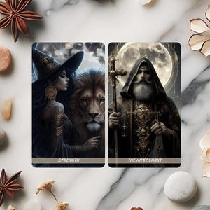 Puede incluir: Dos cartas de tarot con ilustraciones detalladas. Una carta muestra a una mujer con un león, etiquetada como "STRENGTH". La otra representa una figura con túnica y báculo, etiquetada como "THE HIEROPHANT". Las cartas tienen un tema místico y de fantasía con una paleta oscura.