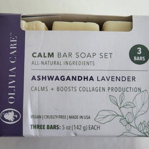 May include: A box set of three bars of soap. The box is white with purple accents and features the text "CALM BAR SOAP SET" and "ASHWAGANDHA LAVENDER". The bars are 5 oz (142 g) each and are all-natural ingredients.