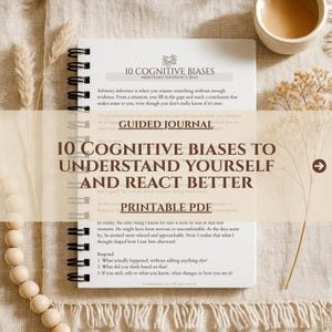 May include: A spiral-bound journal with the title "10 Cognitive Biases to Understand Yourself and React Better." The cover features text and a graphic. The words "Printable PDF" are also visible. The journal is open to a page with text.