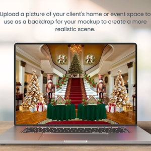 May include: A laptop computer screen displaying a photo of a grand, decorated home interior with a staircase, two Christmas trees, and a nutcracker figurine. The home is decorated with wreaths, garlands, and red and green accents.