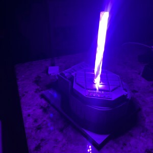 May include: A 3D printed model of the Golden 1 Center, home of the Sacramento Kings, with a purple light shining from the top.