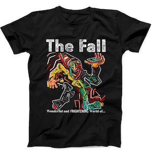 May include: A black short-sleeve t-shirt featuring a colorful, abstract graphic of a figure with a distorted face. The text "The Fall" appears at the top, and "Wonderful and FRIGHTENING World of..." is printed in white at the bottom of the graphic.