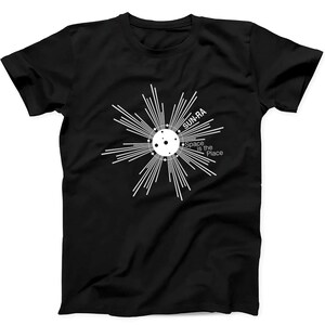 Może przedstawiać: Czarny t-shirt z krótkim rękawem z białym nadrukiem graficznym przedstawiającym centralny okrągły kształt przypominający słońce z promienistymi liniami. Napis SUN-RA oraz Space is the Place jest nadrukowany na biało na klatce piersiowej.