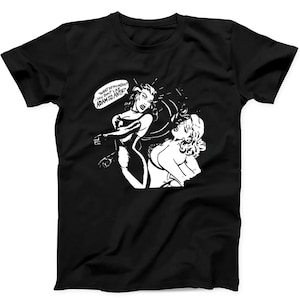 May include: A black short-sleeved t-shirt featuring a white graphic print of a comic book style scene. The illustration depicts one figure slapping another with a speech bubble that reads, "WHAT DO YOU MEAN? YOU DON'T LIKE ADAM AND THE ANTS!"
