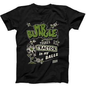 Puede incluir: Una camiseta negra de manga corta con un estampado gráfico que incluye el texto "MR BUNGLE" en verde, "THERE'S A TRACTOR IN MY BALLS AGAIN" en blanco, acompañado de ilustraciones de una flor derritiéndose y varias abejas pequeñas.