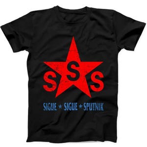 May include: A black short-sleeved t-shirt featuring a large, distressed red star with a black letter S centred inside. Two additional black letters S are positioned to the left and right of the star. Below, the text SIGUE SIGUE SPUTNIK appears in blue.