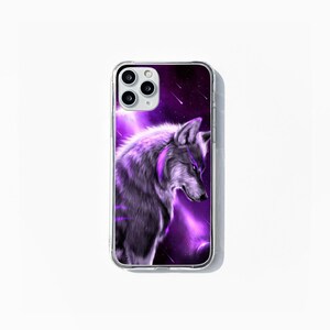 May include: Clear phone case with a detailed illustration of a wolf in shades of purple and grey. The background depicts a purple nebula with shooting stars. The phone case has a clear border and is designed for a smartphone.