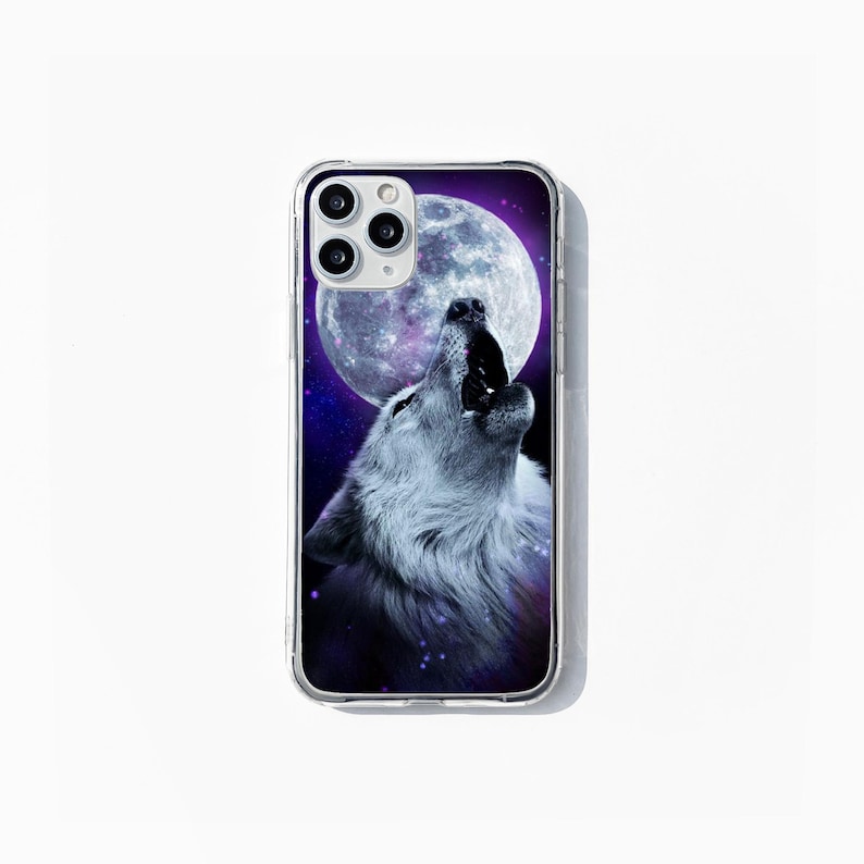 May include: Transparent phone case with a design of a howling wolf under a full moon and a starry night. The wolf is in grey and white, the moon in white and grey. The case is designed for a smartphone.